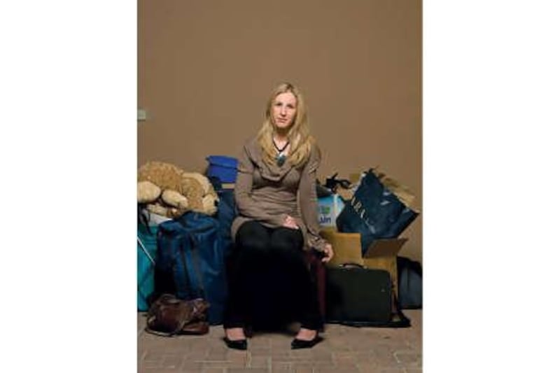 Sophie Martin sits with her belongings for a portrait in the garage of her old apartment in Arabian Ranches.