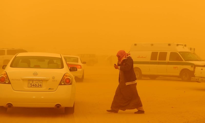 A man walks in the desert camp during a severe dust storm in Rawdatein, 120 Km North of Kuwait City on Saturday, March 17, 2012.  Northwesterly winds of 50 kph carried the dust and sand, to reduce visibility and bring hardship to the desert camp.(AP Photo/Gustavo Ferrari)