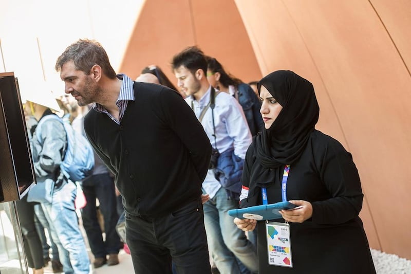 An Emirati volunteer helps a visitor gain a better understanding of the UAE. Giuseppe Aresu / The National