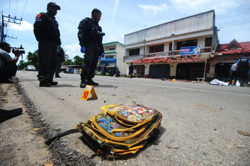 A child's backpack lies on the ground as members of a Thai bomb squad inspect the site of a motocycle blast in front of a school by suspected separatist militants in the Takbai district of Thailand's restive southern province of Narathiwat on September 6, 2016. Madaree Tohlala/AFP