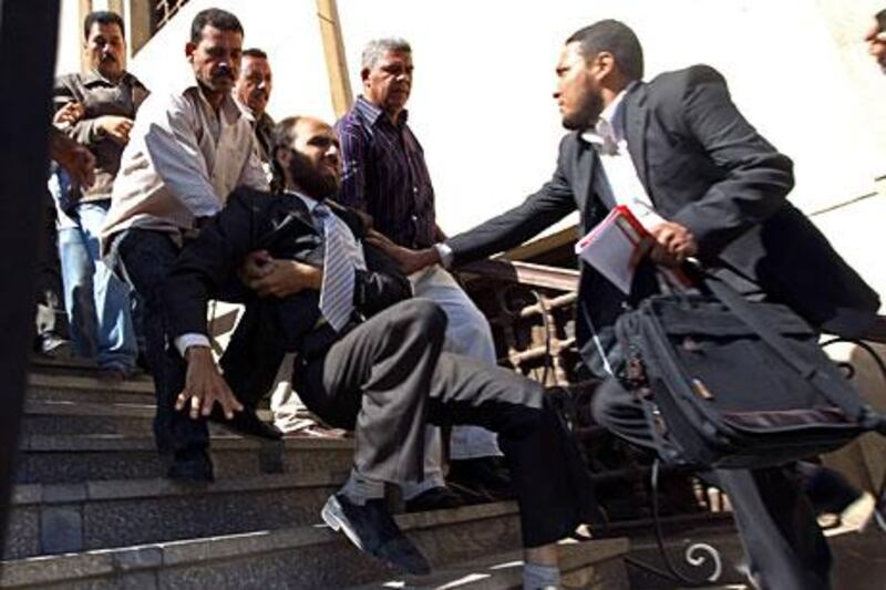 A plainclothes policeman pushes down a Muslim Brotherhood member in Fayoum this month.