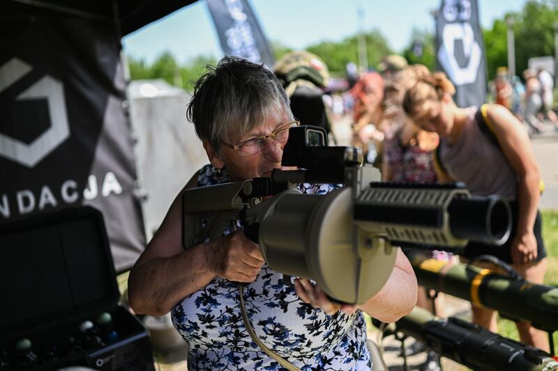 A woman holds a grenade launcher during a military picnic in Siemianowice, Poland. The country is seeking more part-time volunteers for its Territorial Defence Force. Getty Images