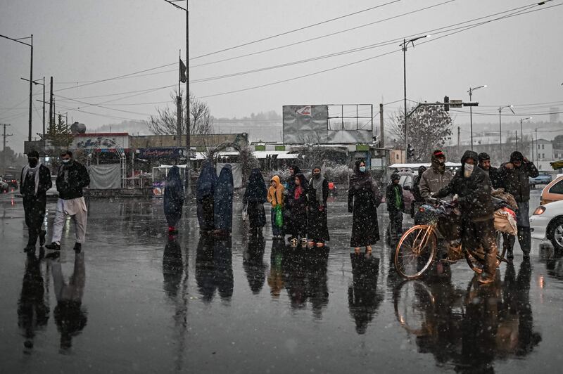People walk along a road during the first snow in Kabul, Afghanistan. All photos: AFP