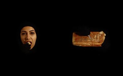 A still from 'The Consumer, The Consumed – Ignorance and Wants' (2014), a two-channel video installation that shows the artist eating a loaf of dry bread. Courtesy of the artist