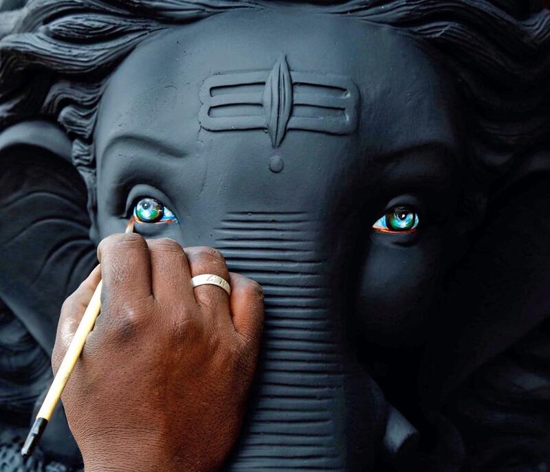 An artist gives the finishing touch to Hindu elephant headed god Lord Ganesha during preparations for the upcoming Ganesh Chaturthi festival at a roadside workshop in Bangalore.  Jagadeesh NV / EPA