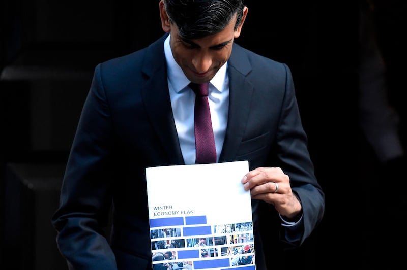 Britain's Chancellor of the Exchequer Rishi Sunak poses with his 'Winter Economy Plan' outside 11 Downing street in central London on September 24, 2020.  Finance Minister Rishi Sunak will unveil his "Winter Economy Plan" before parliament today, amid mounting fear that the end of his furlough jobs retention scheme next month could spark mass unemployment.
 / AFP / DANIEL LEAL-OLIVAS
