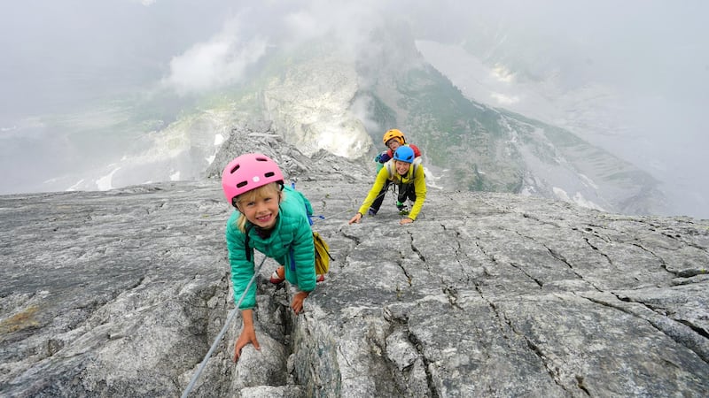 **Sent under embargo, no use before 14.00pm BST August 3 2020*
Freya Houlding with mum behind her on their three day trip to climb Piz Badile. See SWNS story SWPLclimb; A toddler and his seven-year-old sister have smashed records to become the youngest mountain climbers to scale a massive 10,000ft peak and were given a reward - of Haribo. Freya Houlding, seven, and three-year-old Jackson were literally following in their professional climber father's footsteps as he led them up Piz Badile on the border of Switzerland and Italy. Dad Leo Houlding, 40, spends his working life climbing some of the most dangerous and most remote mountains on earth, and his wife, 41-year-old Jessica, a GP, is an avid climber too. And now Freya has become the youngest person to climb the mountain unaided, and Jackson the youngest person to get to the top - 153 years to the day since the peak was first climbed. Jackon says he enjoyed his climb - and the sweets he got as a well done.