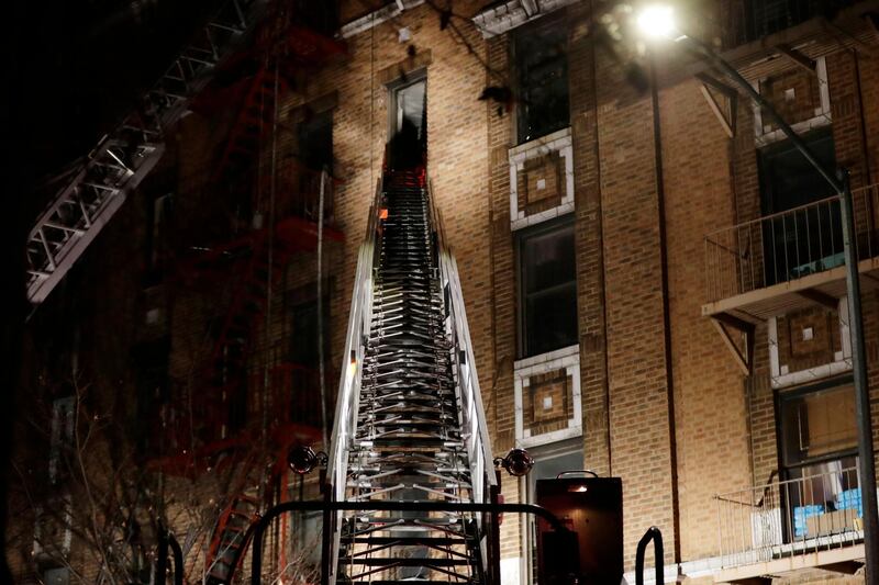 Firefighters climb a ladder to the five-storey building where a fire broke out at about 7pm on December 28, 2017 in the Bronx borough of New York. Frank Franklin II / AP Photo