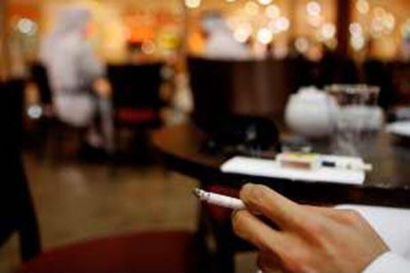 Earlier drafts of the law allowed smoking in designated areas. Above, a man smokes at a cafe in Marina Mall, Abu Dhabi.