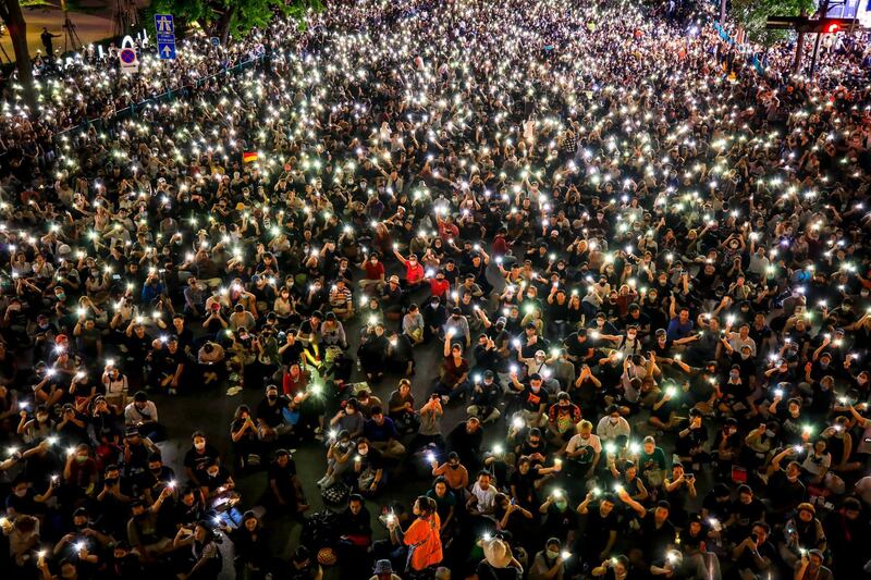 Pro-democracy protesters hold up their mobile phones during rally against the state of emergency at Ratchaprasong shopping district in Bangkok, Thailand.   EPA
