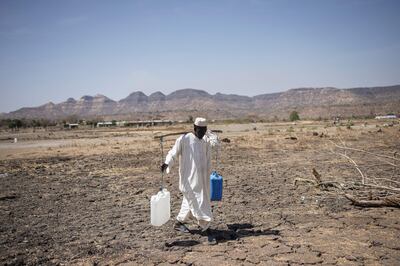 A Sudanese refugee walks back from collecting water in a refugee camp near Maganan, Ethiopia. AFP