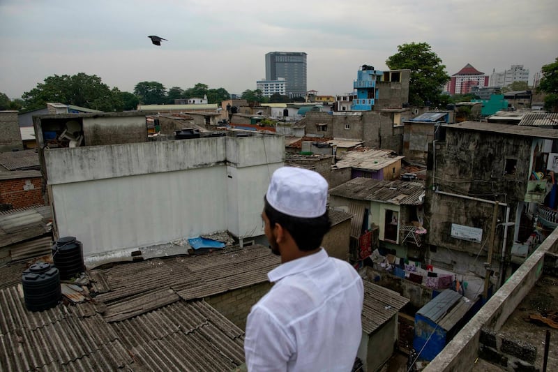 A volunteer stands in a roof of a mosque to spot possible attackers. AP Photo