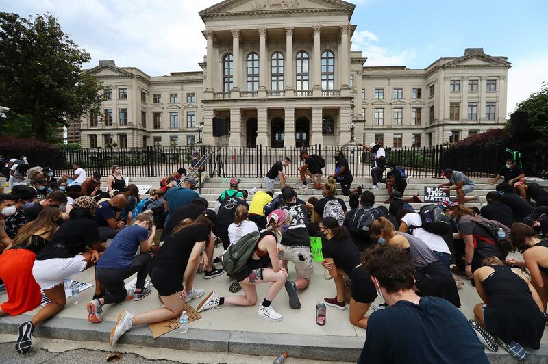 Protesters take a knee for 8 minutes, 46 seconds outside the Capitol, in Atlanta, in memory of George Floyd.   AP
