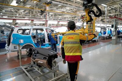 An employe of DHL company (yellow vest) works inside a Baojun car final assembly plant operated by General Motors Co. and its local joint-venture partners in Liuzhou, Guangxi Zhuang Autonomous Region, China, December 27, 2017. Picture taken December 27, 2017. REUTERS/Aly Song