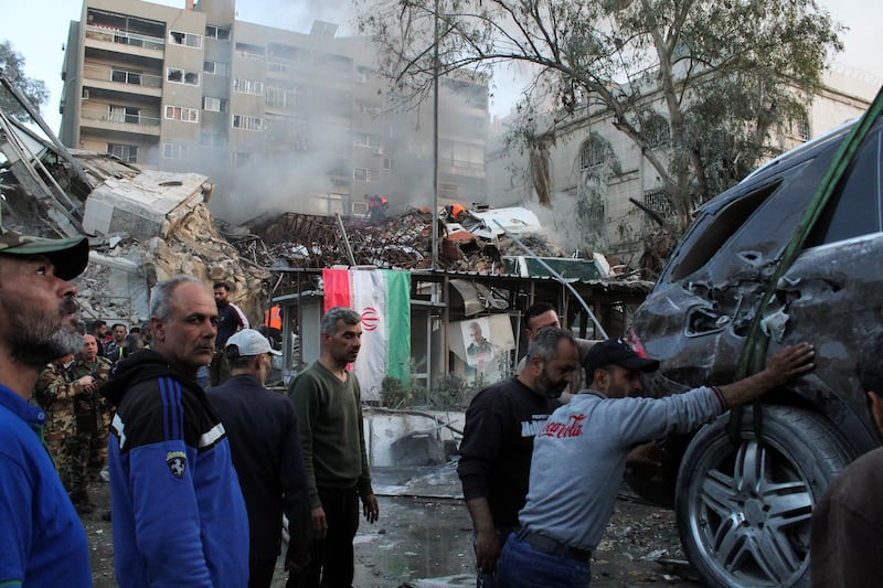 A destroyed vehicle is taken away from the Iranian embassy compound in the Syrian capital. Reuters
