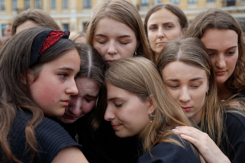 Ukrainian women hug during a rally in Kyiv to call for Russia to be designated as a state sponsor of terrorism. More than 50 Ukrainian prisoners of war, including some who defended Mariupol from within the Azovstal steel plant, were killed last week. Reuters