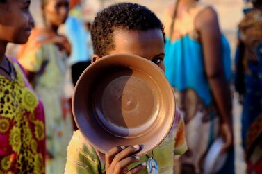 An Ethiopian child who fled war in Tigray region, carries his plate as he queues for wet food ration at the Um-Rakoba camp, on the Sudan-Ethiopia border in Al-Qadarif state, Sudan November 19, 2020. REUTERS/Mohamed Nureldin Abdallah TPX IMAGES OF THE DAY