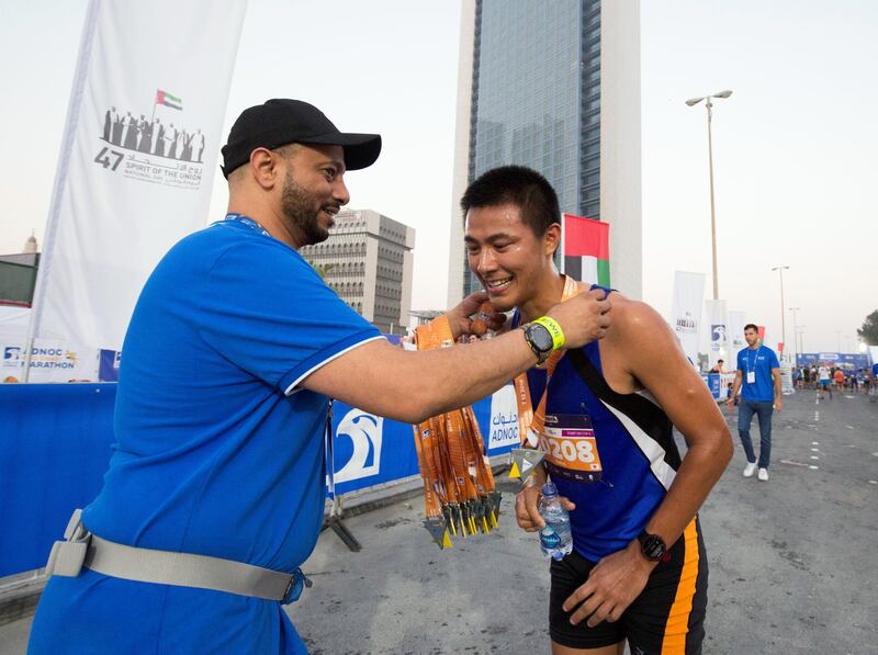ABU DHABI, UNITED ARAB EMIRATES- Participant who finishes at the 10km marathon getting his medal at the ADNOC ABU Abu Dhabi Marathon.  Leslie Pableo for The National 