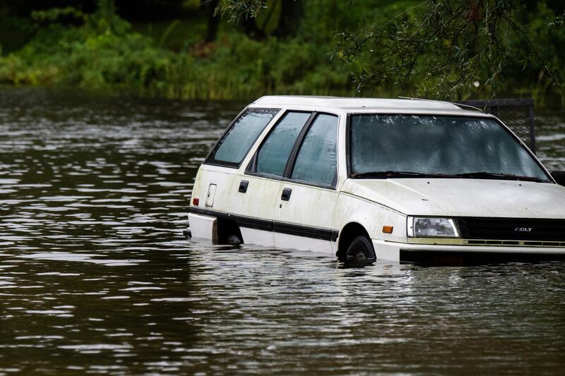An empty vehicle sits in floodwaters in a driveway in Pascagoula, Mississippi.  AP