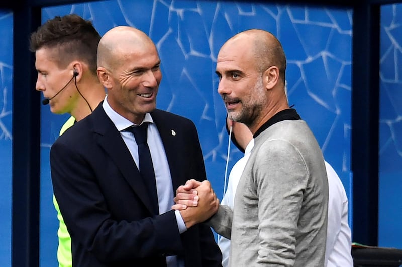 Real Madrid's French coach Zinedine Zidane (L) and Manchester City's Spanish manager Pep Guardiola (R) shake hands prior to the UEFA Champions League round of 16 second leg football match between Manchester City and Real Madrid at the Etihad Stadium in Manchester, north west England on August 7, 2020. (Photo by PETER POWELL / POOL / AFP)