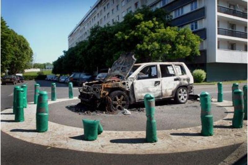 A burnt-out car next to the infamous housing project Quatre Mille in the Paris suburb of La Courneuve, where immigrants have clashed with police.