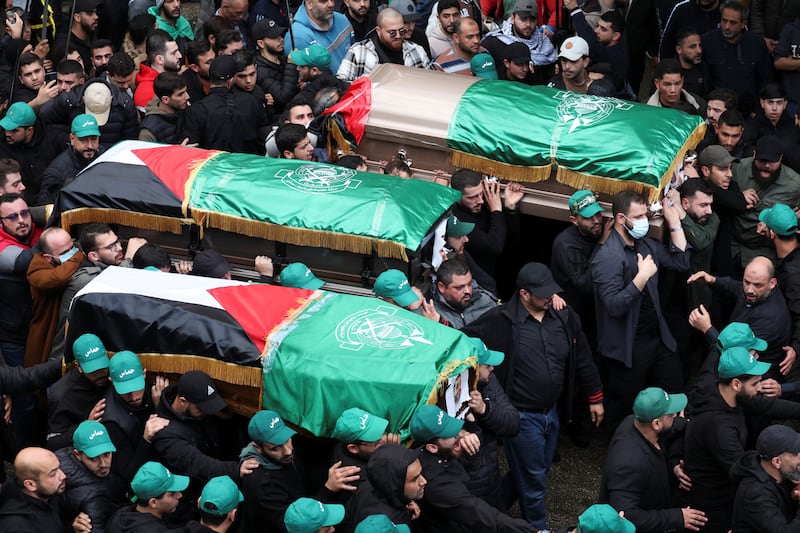 Mourners carry coffins during the funeral procession. Reuters