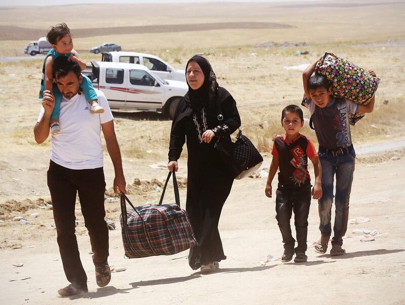 Iraqis who have fled the violence in their hometown of Mosul line arrive at Khazir refugee camp outside of Erbil. AP Photo