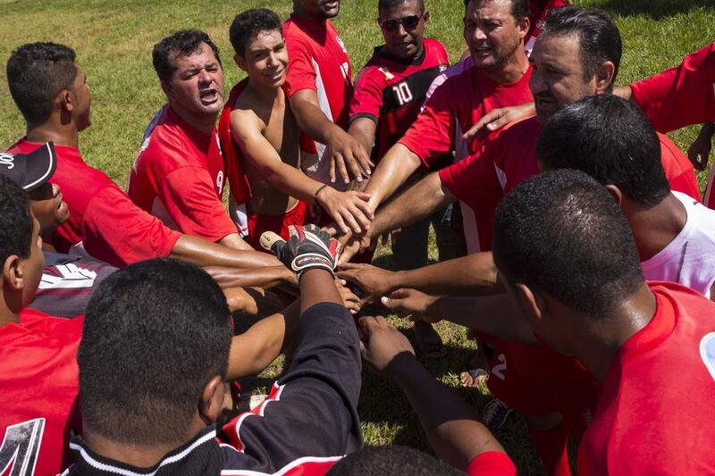 An amateur team join their hands before returning to the field after halftime during a Sunday “pelada” soccer match in Cuiaba. Marcos Lopes / Reuters