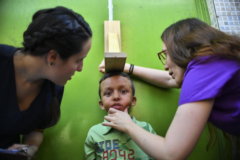 A volunteer of the "Aid and Freedom Coalition" movement takes a child's measurements during a medical attention camp in the Macarao neighbourhood in Caracas, Venezuela. AFP