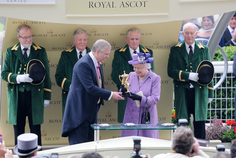 Queen Elizabeth II is presented The Gold Cup by Prince Andrew after her horse Estimate won during Ladies Day of Royal Ascot in 2013.