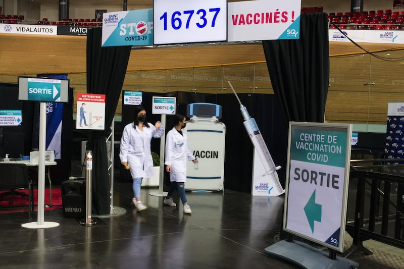 Healthcare workers pass exit signs at the Covid-19 vaccination center inside France's national velodrome in the Saint-Quentin-en-Yvelines district of Paris. Bloomberg