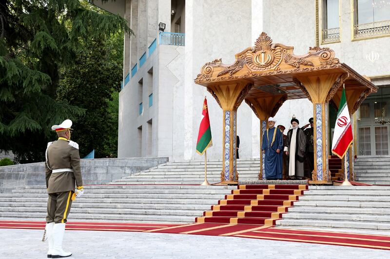 Mr Raisi stands next to Sultan Haitham at the welcoming ceremony in Tehran. Reuters