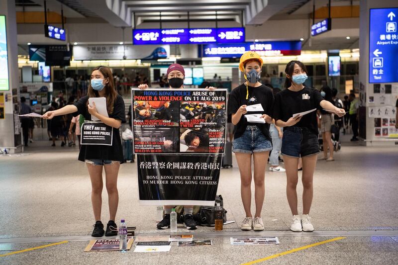 Protesters hand out flyers during a sit-in against police violence in Hong Kong Chek Lap Kok International Airport. EPA