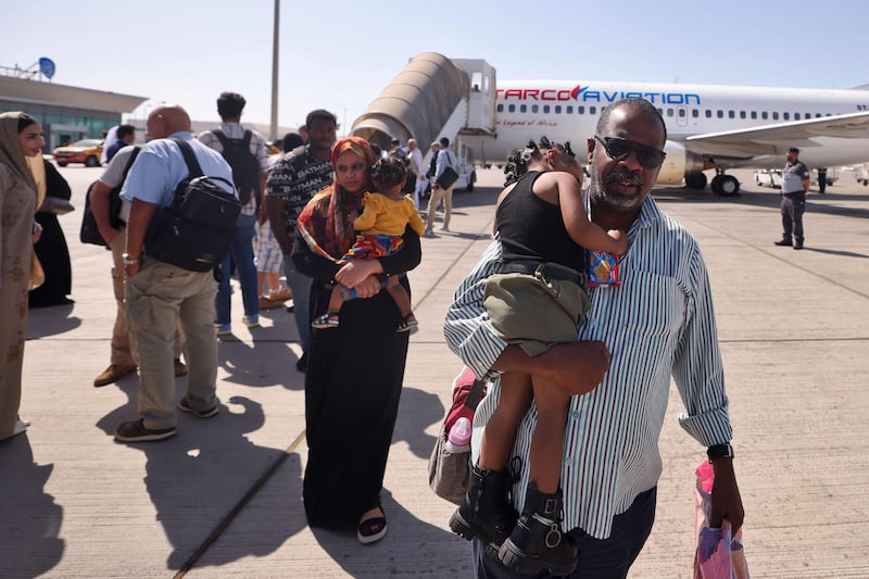 People who fled the conflict in Sudan by air are met by UAE officials in Abu Dhabi on Saturday. AFP