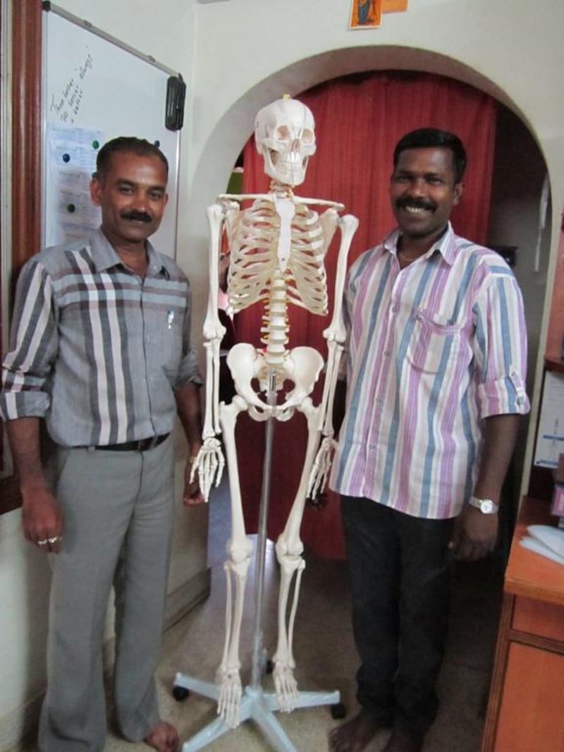 Employees of Biolab India, a Bangalore distributor of artificial skeletons and other teaching aids, pose with a Chinese-made PVC skeleton.  Courtesy Margot Cohen