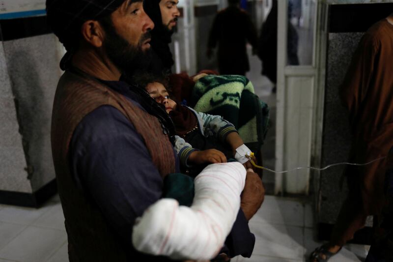 An earthquake survivor carries his child to a hospital in Herat. Reuters