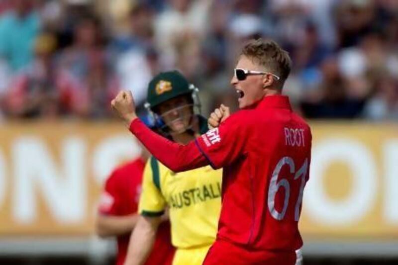 England's Joe Root, right, celebrates after taking the wicket of Australia's Phillip Hughes.