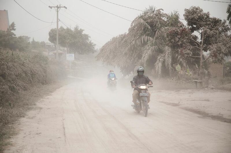 Motorists ride on a road covered in volcanic ash from the eruption of Mount Sinabung in Gurukinayan, North Sumatra, Indonesia. Endro Rusharyanto / AP Photo