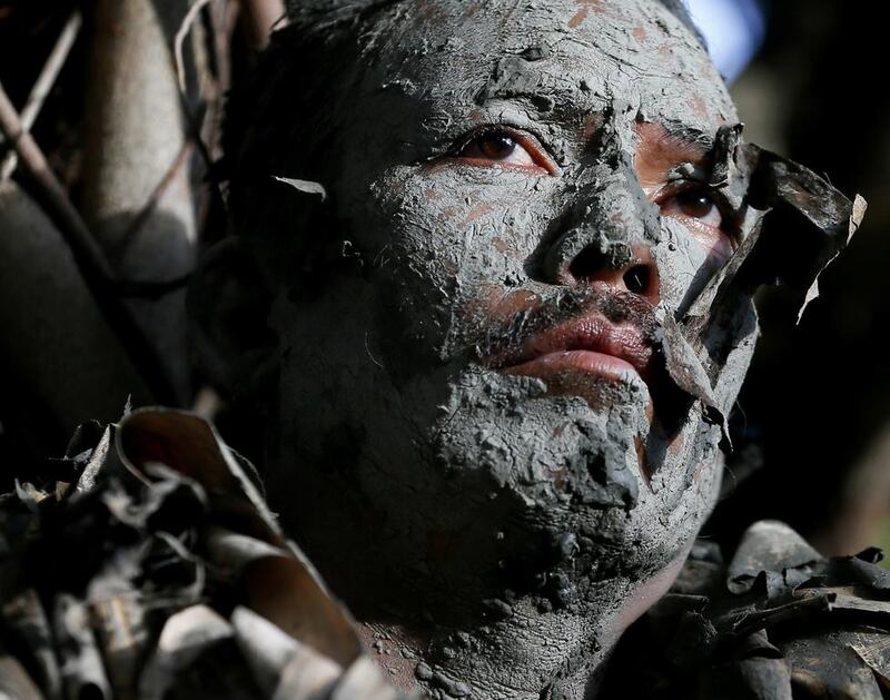 A villager, donning capes mostly of dried banana leaves and covered in mud, attends a mass during the ‘Taong Putik’ or ‘mud people’ festival in an annual ritual to venerate their patron saint, John the Baptist at Bibiclat, Aliaga township, Nueva Ecija province in northern Philippines. Bullit Marquez / AP Photo