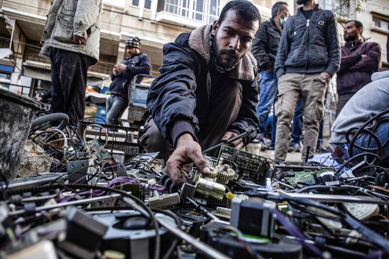 Abu Raida searches for spare parts at a scrap market in Bani Suhaila. AFP
