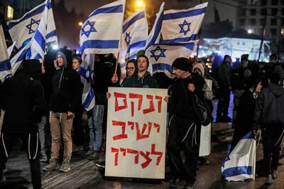 A demonstrator holds a Hebrew sign which quotes the biblical verse "he will take vengeance on his enemies", during a far-right protest in the Sheikh Jarrah neighbourhood of occupied East Jerusalem, on December 8. AFP