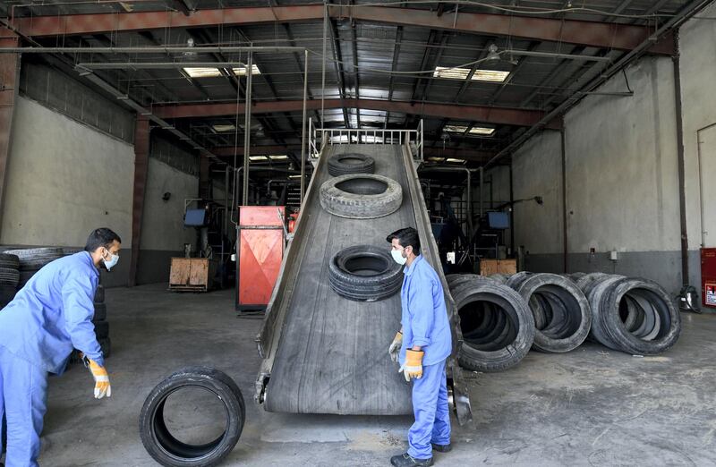 Abu Dhabi, United Arab Emirates - The workers place the used tire on the belt for shredding, and purification process to begin at the Gulf Rubber factory in Al Ain. Khushnum Bhandari for The National
