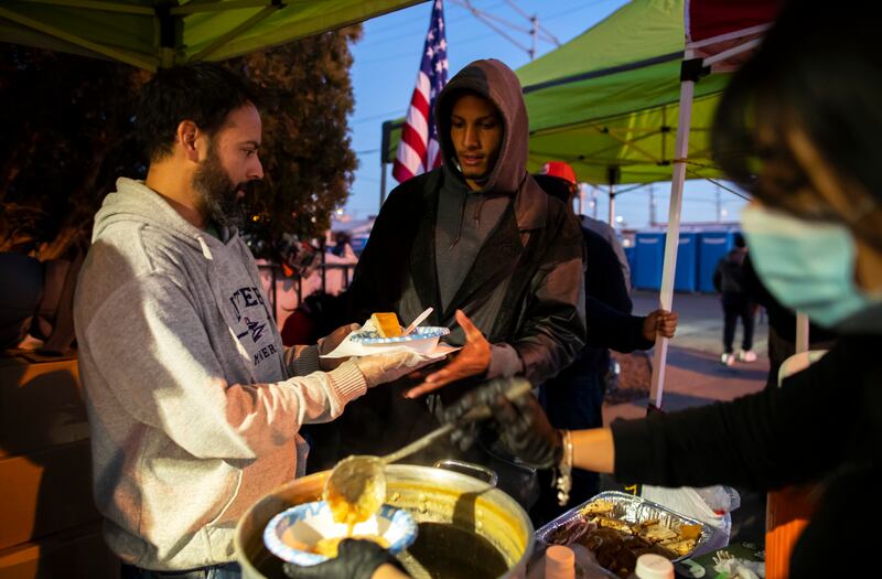 Hot meals are served by volunteers outside the Sacred Heart Church. AP