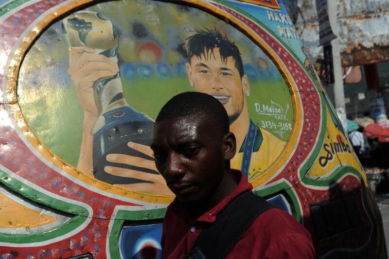 A man walks past by a bus painted with the face of Brazilian football player Neymar in Port-au-Prince. Popularly these buses are called TapTap and are painted with faces of football players, international personalities and other striking designs. Hector Retamal / AFP