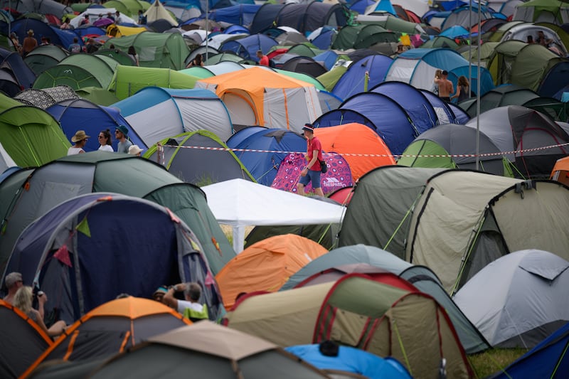 A festivalgoer walks between the tents in one of the camping areas. The festival has returned for the first time since the coronavirus pandemic began. Getty Images