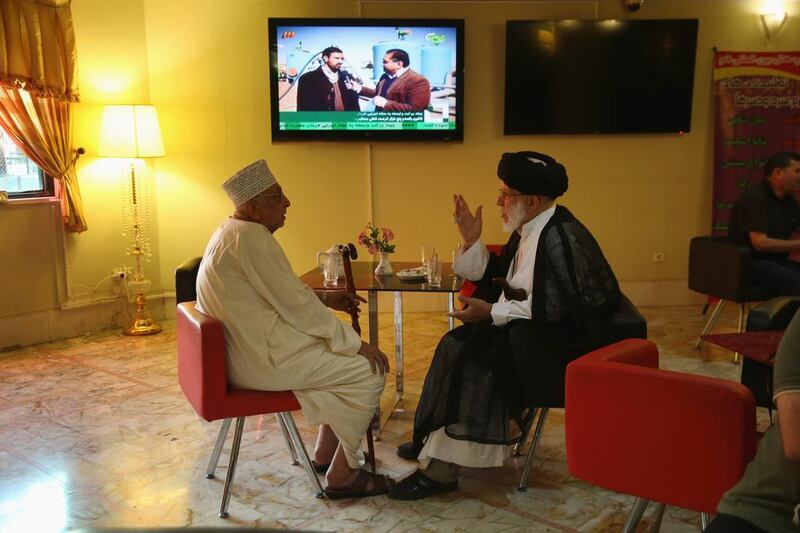 A pair of Arab clerics speak in a hotel coffee shop before prayers at an Islamic shrine in Qom.  