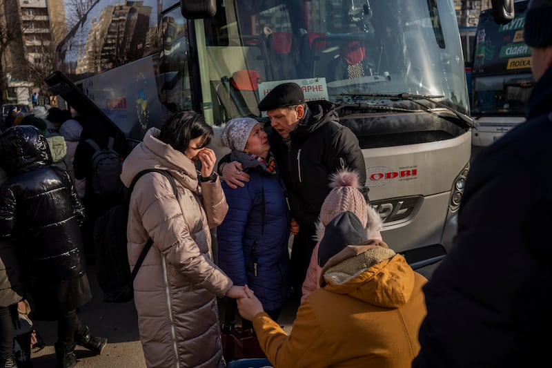 Ukrainian families say goodbye as they prepare to board a bus to Poland at Lviv, western Ukraine. AP