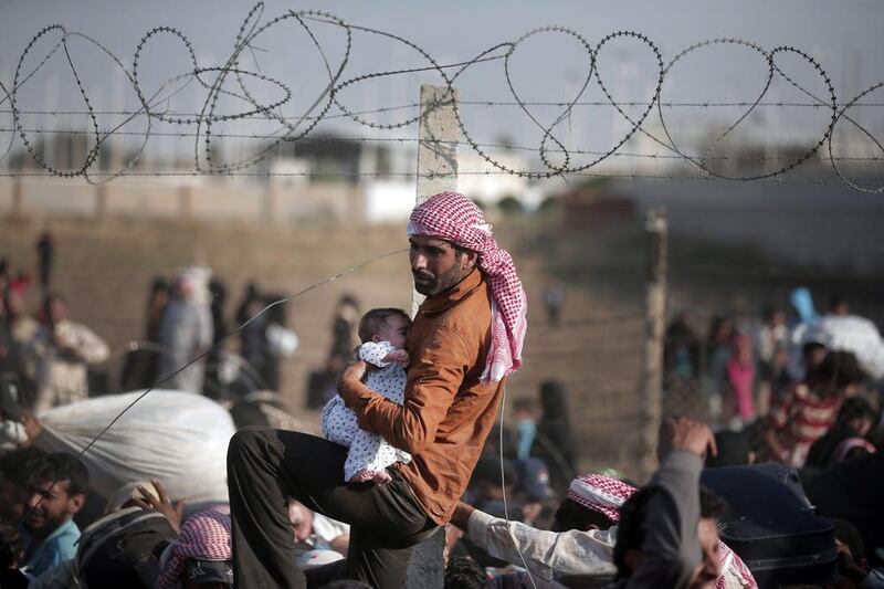 others managed to climb over, throwing their bags over the fence. Bulent Kilic/AFP Photo