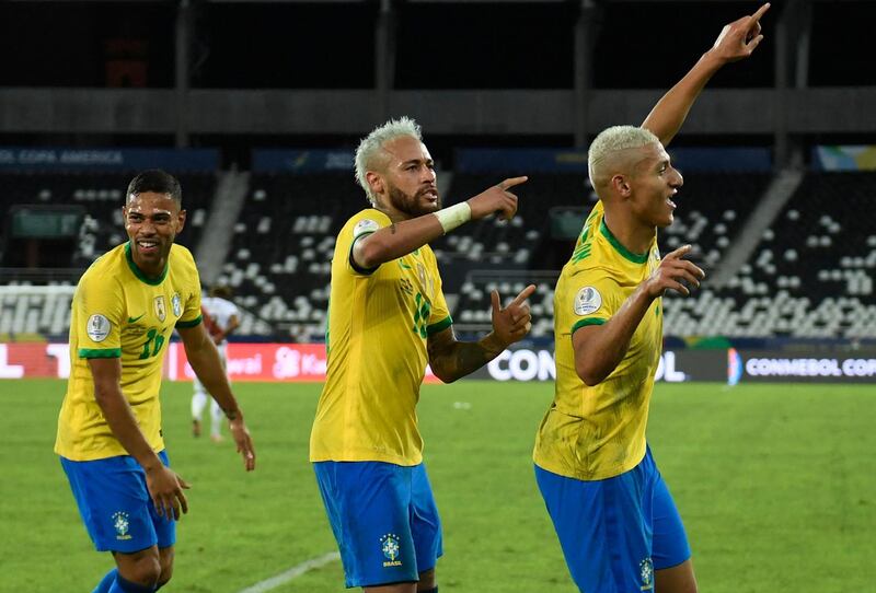 Brazil's Richarlison celebrates followed by teammates Neymar and Renan Lodi after scoring against Peru. AFP