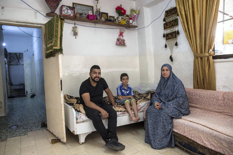 Motes Abu Khader,26, and his mother Nada.47, inside their hime in the Aida refugee camp near the Palestinian city of Bethlehem on June 23,2019. Eight family members live in the home . Photo by Heidi Levine for The National